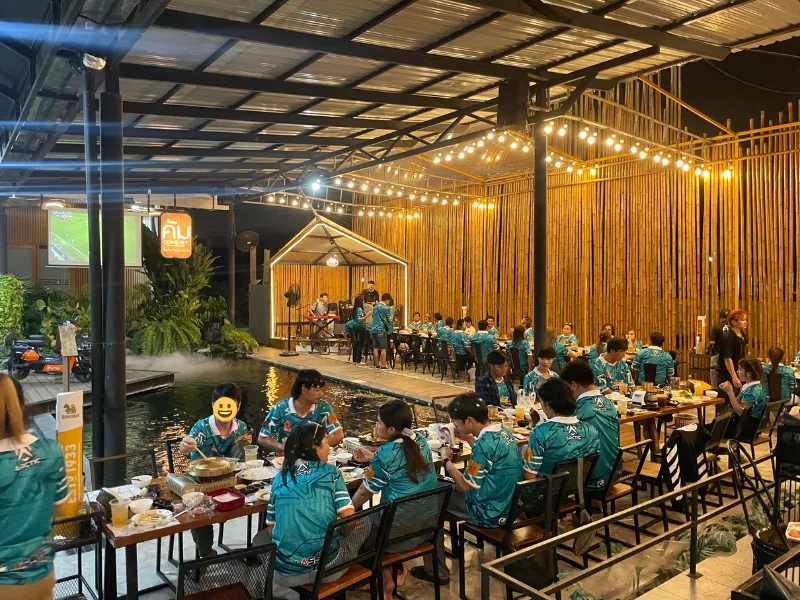 บรรยากาศงานเลี้ยงบริษัทตอนกลางคืน มีแสงสีและดนตรีสดที่ร้านคัม
