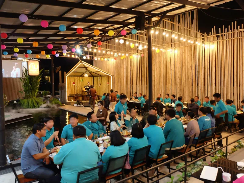 แขกในงานเลี้ยงกำลังนั่งฟังดนตรีสด บรรยากาศชิลๆ ริมบ่อปลาคราฟที่ร้านคัม ขอนแก่น
