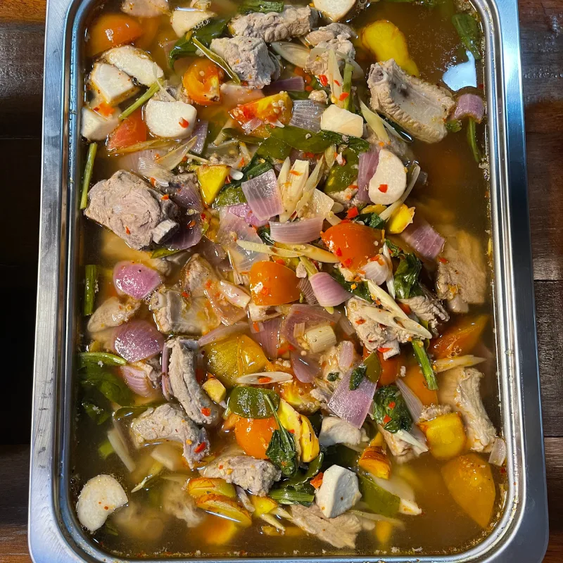 ต้มยำซี่โครงหมูอ่อนน้ำข้นรสจัดจ้าน เสิร์ฟเป็นแกงหม้อสำหรับงานเลี้ยง ร้านคัม