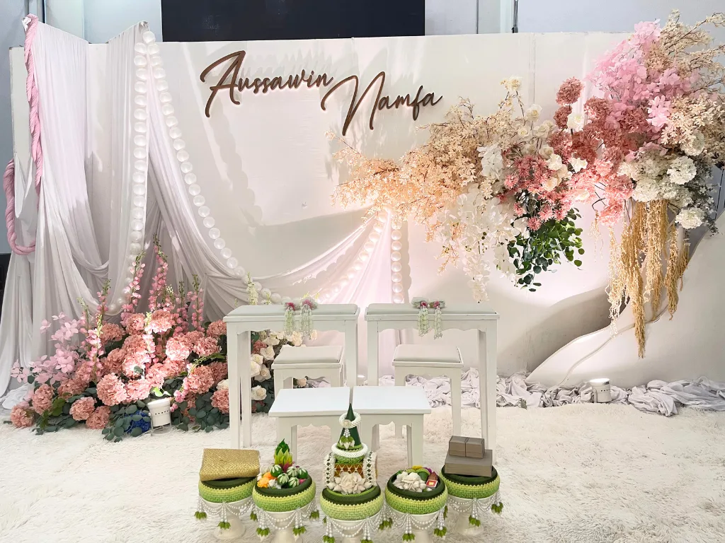 ฉากพิธีมงคลสมรสและชุดตั่งรดน้ำสังข์ ตกแต่งธีมสีชมพู-ขาว พร้อมพานขันหมากเอก 5 พาน สำหรับงานแต่งงานพิธีเช้า ร้านคัม ขอนแก่น
